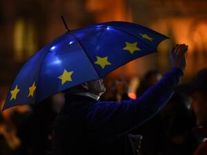 A Pro-EU anti-Brexit protsters with an umbrella decorated in teh style of the EU flag is seen outside the Houses of Parliament in central London. (AFP/ File)