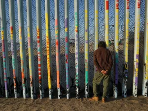  A man looks through the U.S.-Mexico border wall in the Las Playas area on January 6, 2019 in Tijuana, Mexico. (AFP/File)