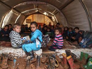 Syrian children gather in a tent repurposed as a make-shift classroom, at a camp for the displaced near the town of Sarmada in the northern countryside of the rebel-held Idlib province on December 1, 2018. (File/ AFP