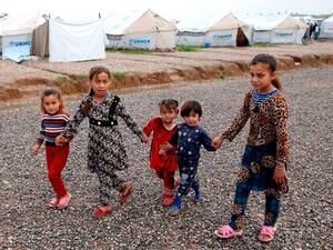 Displaced Iraqi children, who fled Mosul, walk at the Hasan Sham Camp, 30 kilometres east of Mosul, on Friday (AFP)