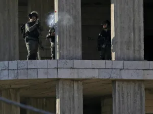 An Israeli soldier fires a tear gas canister at Palestinian stone throwers following a raid in the West Bank city of Ramallah, 10th of December. (AFP)