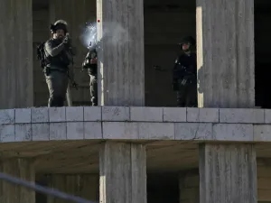 An Israeli soldier fires a tear gas canister at Palestinian stone throwers following a raid in Ramallah. (AFP/ File)