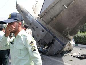 Iranian security forces stand at the scene of a previous plane crash near Tehran's Mehrabad airport on August 10, 2014. (AFP/ File)