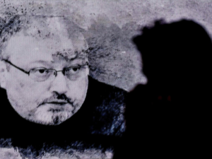 A man passes in front of a screen showing Jamal Kashoggi during a commemoration event of Khashoggi's supporters on November 11 in Istanbul. (AFP)