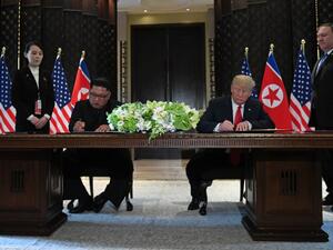 North Korea's leader Kim Jong-un and US President Donald Trump sign documents, June 12, 2018. (AFP/ File)