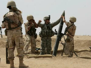 A US military adviser helps soldiers from the 17th Iraqi army brigade load a mortar. (AFP/ File)