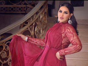 ارتدت أحلام خلال جلسة التصوير فستان رقيق باللون الأحمر النبيذي facebook.com