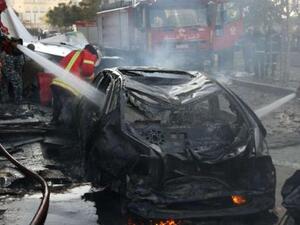 Lebanese douse a burring vehicle set ablaze by a massive car bomb explosion that rocked central Beirut on December 27, 2013. [AFP]