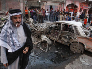 Residents gather at the site of a bomb attack in Basra. [AFP]