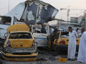 Two men inspect the site of a car bomb that went off in the mostly Shia Sadr City district of Baghdad on October 13, 2014. (AFP/Ahmad al-Rubaye)