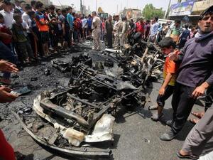 Iraqis look at the damage following a car bomb attack in Sadr City. (AFP/File)