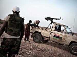 A Libyan rebel fighter waits nervously for the road to be cleared of mines near the front line. (AFP/Colin Summers)