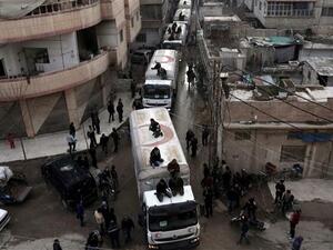 This photo taken on February 23, 2016 shows a Red Crescent convoy of humanitarian aid arriving in Kafr Batna, in the militants-held Eastern Ghouta area, on the outskirts of the capital, Damascus. (AFP/File)