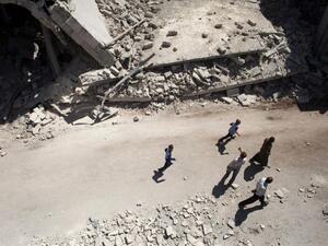 Syrians walk past destroyed buildings in Al-Bab in the northern province of Aleppo on 1 September 2012. (AFP/Achilleas Zavallis)