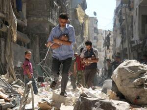 Syrian men carrying babies make their way through the rubble of destroyed buildings following a reported airstrike in Aleppo, Syria. (AFP/File)