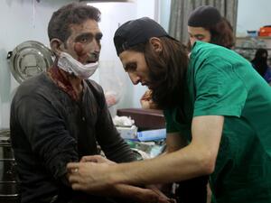 Syrian medics treat a man at a makeshift hospital in the Tariq al-Bab neighborhood. (AFP/File)