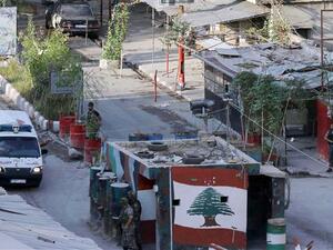 Members of the Palestinian Fatah movement and Lebanese army soldiers watch as an ambulance evacuates the wounded from Ain al-Hilweh refugee camp. (AFP/File)