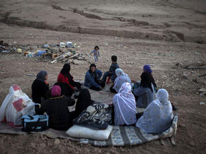 Bedouin women from al-Turi family sit next to their destroyed homes in their village. (AFP/File)