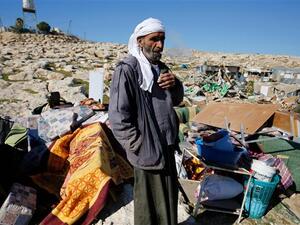 Palestinian Bedouin Abu Nawar stands next to the remains of makeshift homes that were demolished by Israeli forces east of al-Quds (Jerusalem) in the occupied West Bank, on January 6, 2016. (AFP/File)