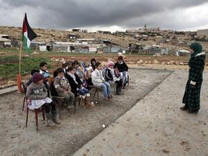 A Palestinian teacher leads a class of Palestinian Bedouin children from the Abu Anwar community. (AFP/File)