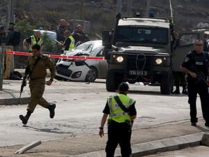 Israeli security forces gather at the scene where a Palestinian man was shot dead by Israeli security forces after ramming his car into a group of Israelis at Tapuah junction, south of Nablus in the West Bank, on November 8, 2015. (AFP/Jaafar Ashtiyeh)