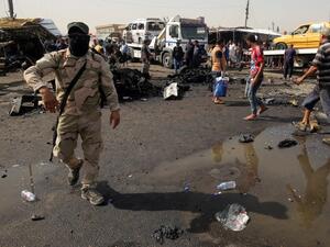 Iraqi soldiers and civilians check the damage after a suicide bomber detonated an explosives-rigged vehicle in northern Baghdad's Sadr City, May 17, 2016. (AFP/Ahmad al Rubaye)