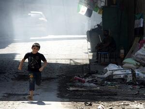 A Syrian boy runs to cross a street where snipers take positions in the old city of Aleppo. (AFP/File)