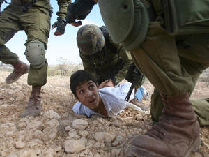 A Palestinian youth is arrested by Israeli soldiers for throwing stones during a protest. (AFP/Hazem Bader)