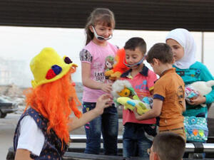 This undated photo courtesy of Ahmad al-Khatib, a media activist in Aleppo, shows Syrian social worker Anas al-Basha, 24, dressed as a clown, distributing toys to children in Aleppo, Syria. (Twitter)