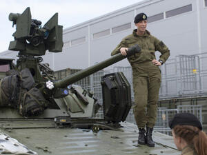 Female soldiers talk next to a CV90 combat vehicle. (AFP/File)