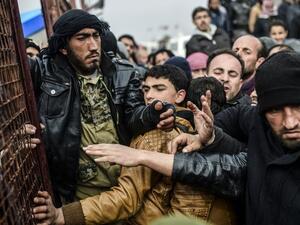 Refugees push each other as they wait for tents as Syrians fleeing the northern embattled city. (AFP/File)