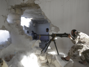 A Free Syrian Army fighter fires a weapon inside a damaged building during clashes with forces from the Syrian regime. (AFP/File)