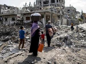 A displaced Palestinian family returns home amid the destruction in part of the northern Beit Hanun district of Gaza Strip. (AFP/File)