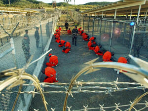 Al-Qaeda and Taliban detainees sit in a holding area under the surveillance of U.S. Military police at Camp X-Ray, a temporary prison site at Guantanamo Bay. (AFP/File)
