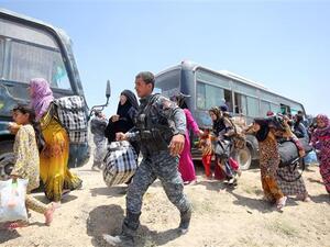 Iraqi forces help families near al-Sejar Village, in Iraq’s Anbar Province, after helping them flee the city of Fallujah, May 27, 2016. (AFP/File)