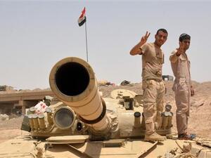 Iraqi government forces flash the sign of victory on their tank on June 22, 2016, some 40 kilometers (25 miles) west of Qayyarah, during their operation to take the city and make it a launch pad for an assault on Mosul. (AFP/File)