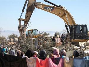Palestinian family looks on as Israeli authorities demolish home. (Twitter)