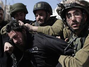 In this file photo, Israeli soldiers violently arrest a Palestinian demonstrator during a protest. (AFP/File)