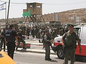 Israeli forces stand guard near the Zaatara military checkpoint where a Palestinian was shot dead stabbing a border police officer in August, 2015. (AFP/Jaafar Ashtiyeh)