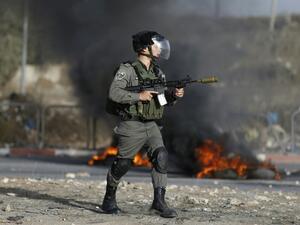 An Israeli border guard holds a rifle with a rubber bullet attachment during clashes with Palestinian youths in the West Bank town of al-Ram, north of Jerusalem, on October 9, 2016. (AFP/Abbas Momani)