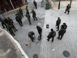 Israeli security forces clean the pavement at the site where a Palestinian was shot dead after stabbing a border policeman on April 25 2015 near the Tomb of the Patriarchs. (AFP/File)
