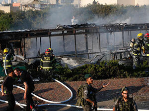 Israeli security forces stand guard as firemen extinguish a burning bus following an attack in Jerusalem on April 18, 2016. (AFP/File)