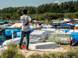 A refugee looks at the “Jungle” camp for in Calais on June 24, 2016. (AFP/File)