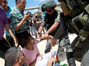 Israeli forces scuffle with Palestinian protesters during clashes following a demonstration against land confiscation for Israel's apartheid barrier in the West Bank. (AFP/File)