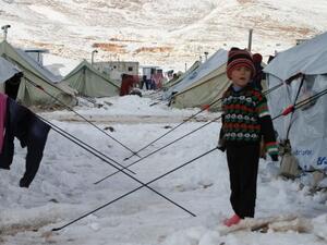 A Syrian child stands in the snow in a refugee camp in the town of Arsal in the Lebanese Bekaa valley on December 13, 2013. (AFP/File)