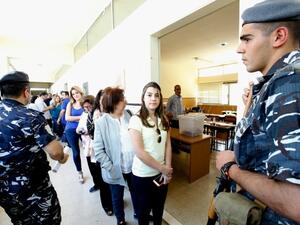 Lebanese security forces stand guard as women stand in line to cast their vote. (AFP/File)