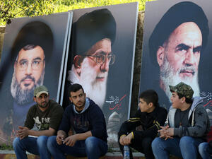Young Lebanese sit below posters of Shia leaders including Hezbollah's Hassan Nasrallah. (AFP/File)