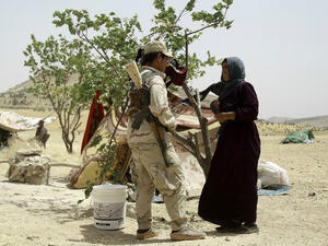 A Syrian woman who fled the assault launched by Arab and Kurdish forces against Islamic State (IS) fighters in the town of Manbij talks to a Kurdish fighter upon her arrival at an encampment on the outskirts of the town, June 4, 2016. (AFP/Delil Souleiman)