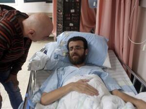 Mohammed al-Qiq, a Palestinian prisoner on hunger strike, talks to a man in a hospital in the northern Israeli town of Afula on February 5, 2016. (Ahmad Gharabli/AFP)