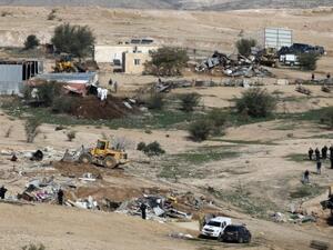 Israeli policemen stand guard as bulldozers demolish homes in Bedouin villages. (AFP/File)